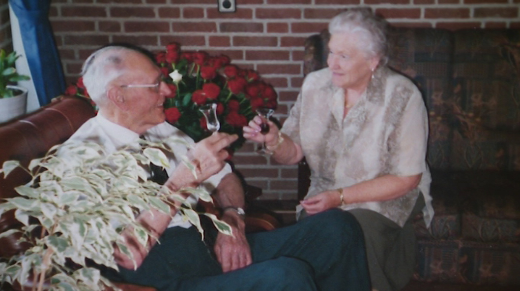 Foto: Jan Thus en Miep. Op de achtergrond de bos met 60 rozen ter ere van hun 60-jarige vriendschap.